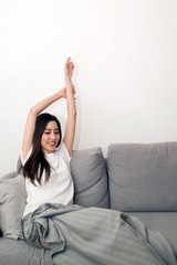 Asian woman relaxed and resting breathing fresh on sofa at home.