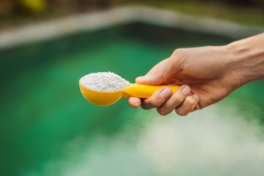 Hand holding Chlorinefor water in the pool