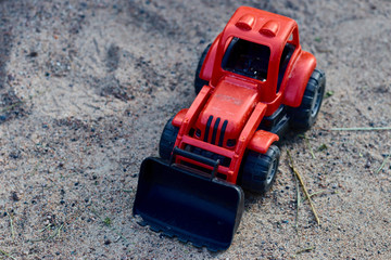 Teddy red tractor in the sand. Kids toys. toy concept for children. copy space.