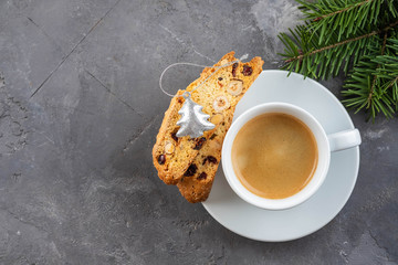 Traditional Christmas pastries, Italian homemade double-baked biscotti or cantuccini cakewith coffee, with nuts and dried fruits. with xmas decorations and fir branches.
