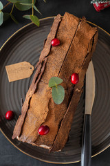 Buche de Noel. Traditional Christmas dessert, Christmas yule log cake with chocolate cream, cranberry. Copy space.