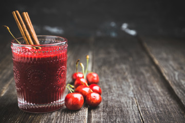 Cherry smoothie with cinnamon in old fashioned glass on the rustic wooden background. Selective focus. Shallow depth of field.