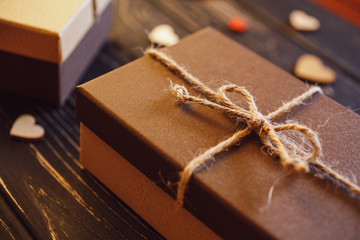 Brown gift boxes on a wooden background with a bow of a simple rope on wood backgraund.