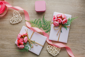 Eco style gift wrapping. Composition with gift boxes decorated with green branch and rose.