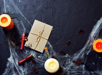 Halloween vintage envelope with stamp. burning candles and spiders on the web next to a wooden cross. Flat lay, top view, copy space. horizontal