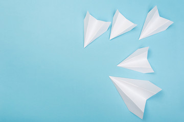 white paper airplane on a navy paper background