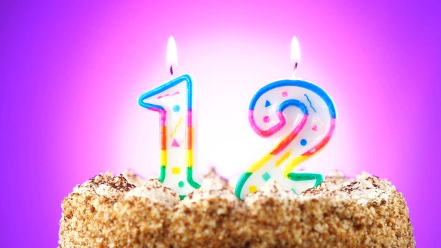 Birthday cake with a burning birthday candle. Number 12. Background changes color