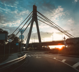 Obraz premium Northern bridge (Moskovskiy bridge) and road during golden hour at the sunset in the Kyiv, Ukraine