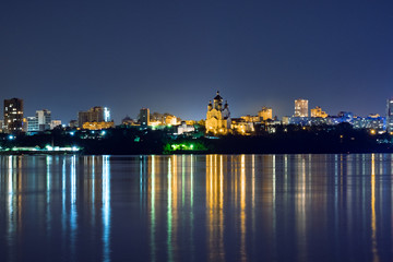 Naklejka premium Night View of the city of Khabarovsk from the Amur river. Blue night sky. The night city is brightly lit with lanterns. The level of the Amur river at around 159 centimeters.