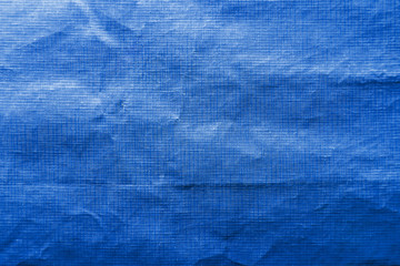 Dirty crumpled blue synthetic fabric texture with a well-traced light and shadow pattern