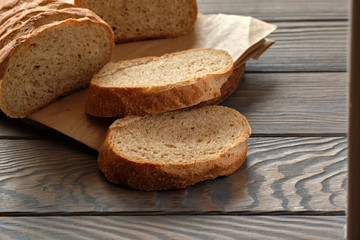 Bread and slices on wooden table