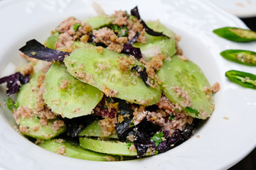 Traditional salad with vegetables and nuts in Georgia. Sliced cucumbers with basil, parsley and walnuts. Delicious vegetable salads for vegetarians.