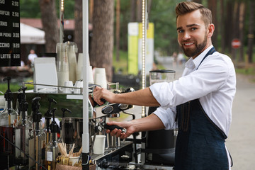 Handsome barista man during work in his street coffee shop - obrazy, fototapety, plakaty
