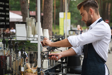 Handsome barista man during work in his street coffee shop