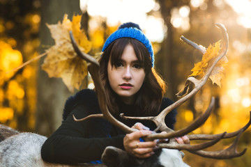 Fototapeta na wymiar a beautiful girl model walking with deer in the park