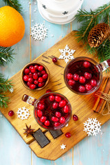 Christmas, Thanksgiving drinks. Hot winter drink with cranberries and cinnamon on wooden table. Top view flat lay.