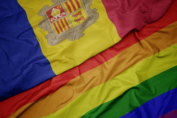 waving colorful gay rainbow flag and national flag of andorra.