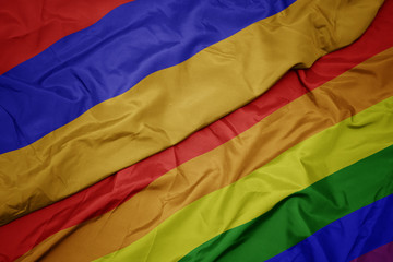 waving colorful gay rainbow flag and national flag of armenia.