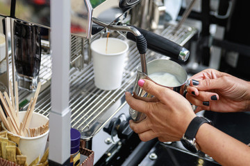 Barista is preparing coffee with milk