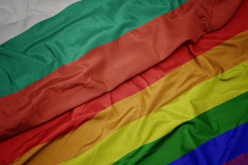 waving colorful gay rainbow flag and national flag of bulgaria.