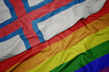 waving colorful gay rainbow flag and national flag of faroe islands.