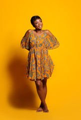 Portrait of a beautiful young African woman over yellow background. Studio picture