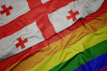 Fototapeta premium waving colorful gay rainbow flag and national flag of georgia.