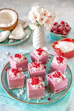 Raw vegan mini-cakes volcanoes made from fermented cashew butter, with raspberry jam lava, decorated with shredded coconut and sublimated raspberries. Gluten-free, no eggs. Healthy eating concept.