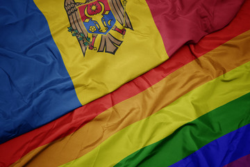 waving colorful gay rainbow flag and national flag of moldova.