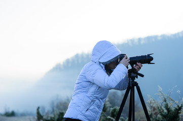 photographer with camera and tripod outdoor taking landscape picture