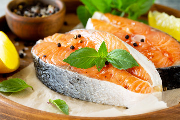 Steak raw fish prepared for cooking. Salmon wiht basil and spices on slate table.