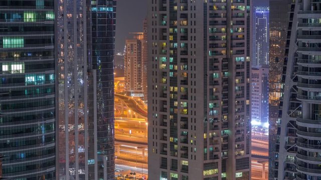 Residential and office buildings in Jumeirah lake towers district night timelapse with blinking lights in windows in Dubai. Aerial view from above with modern skyscrapers