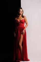 Fototapeta premium gorgeous woman in red dress. Studio picture, grey background