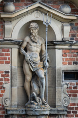 Obraz premium A statue of Poseidon, standing in a niche with his trident at Frederiksborg Castle, Denmark