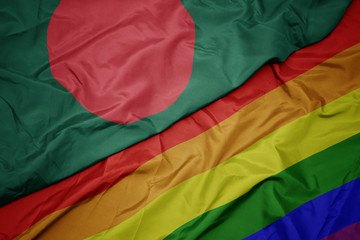 waving colorful gay rainbow flag and national flag of bangladesh.