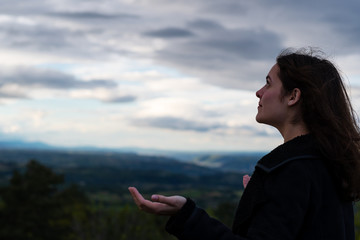 Naklejka premium Christian worship and praise. A young woman is praying and worshiping in the evening.