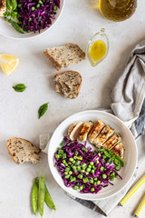 Grilled chicken, red cabbage, green peas and beans on light background. Delicious balanced food concept. Healthy lunch or dinner salad.