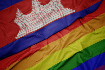 waving colorful gay rainbow flag and national flag of cambodia.