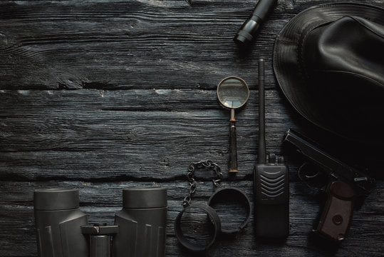 Detective or spy agent wooden black table flat lay background with copy space. Secret service agent work table.