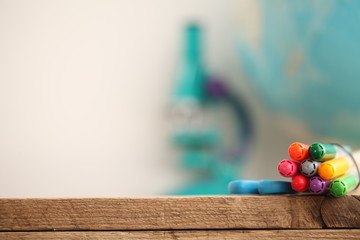 Concert education globe books microscope and pencils on background.