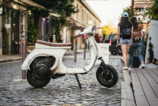 Old small white scooter parked in a cobbled street