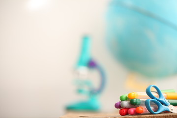 Concert education globe books microscope and pencils on background.