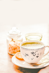 green tea matcha soy latte in a china cup with brown sugar and a glass of water on the side