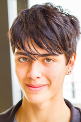 Mixed race male teenager with earring smiling into the camera