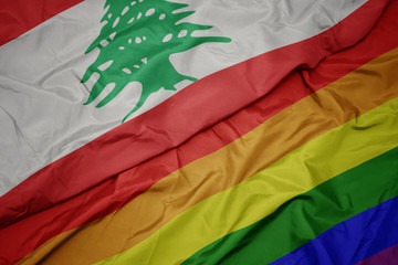 waving colorful gay rainbow flag and national flag of lebanon.