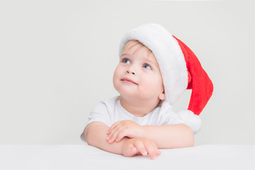 blue-eyed baby boy wearing a Santa hat