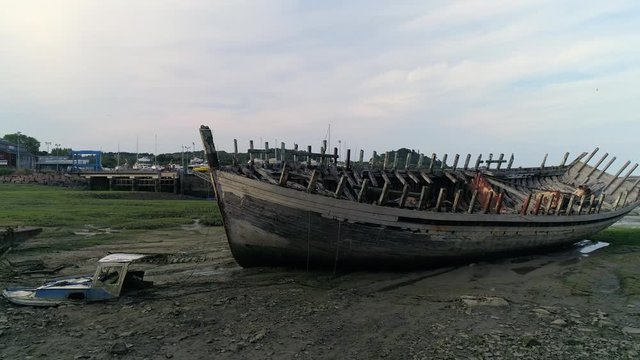 Aerial view. Skeleton of an old abandoned wooden boat. Cemetery of dead ships. Broken deserted vessel aground.