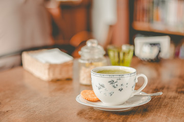 green tea matcha soy latte in a china cup with brown sugar and a glass of water on the side