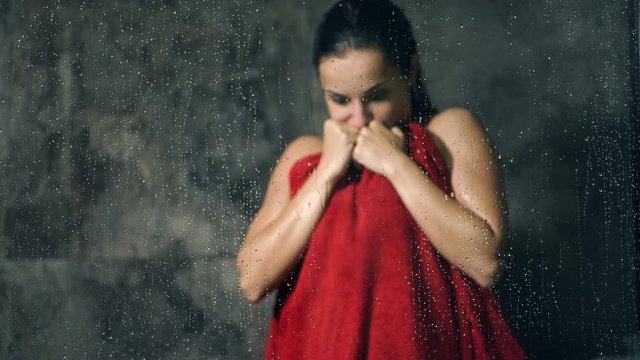 Shaking, frozen woman standing in the bathroom. No hot water in the shower.