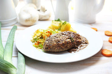 Cutlet with potatoes and white cabbage salad. Dinner dish.
